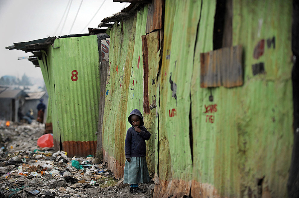 A girl stood outside a school in the Mukuru kwa Njenga slum in Nairobi, Kenya, Tuesday. An Amnesty International Report released Tuesday says the government has failed to incorporate slums, leaving women vulnerable to sexual and other attacks.) [Credit: Tony Karumba/Agence France-Presse/Getty Images]